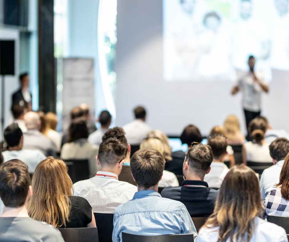 conference, one person speaking, others listening